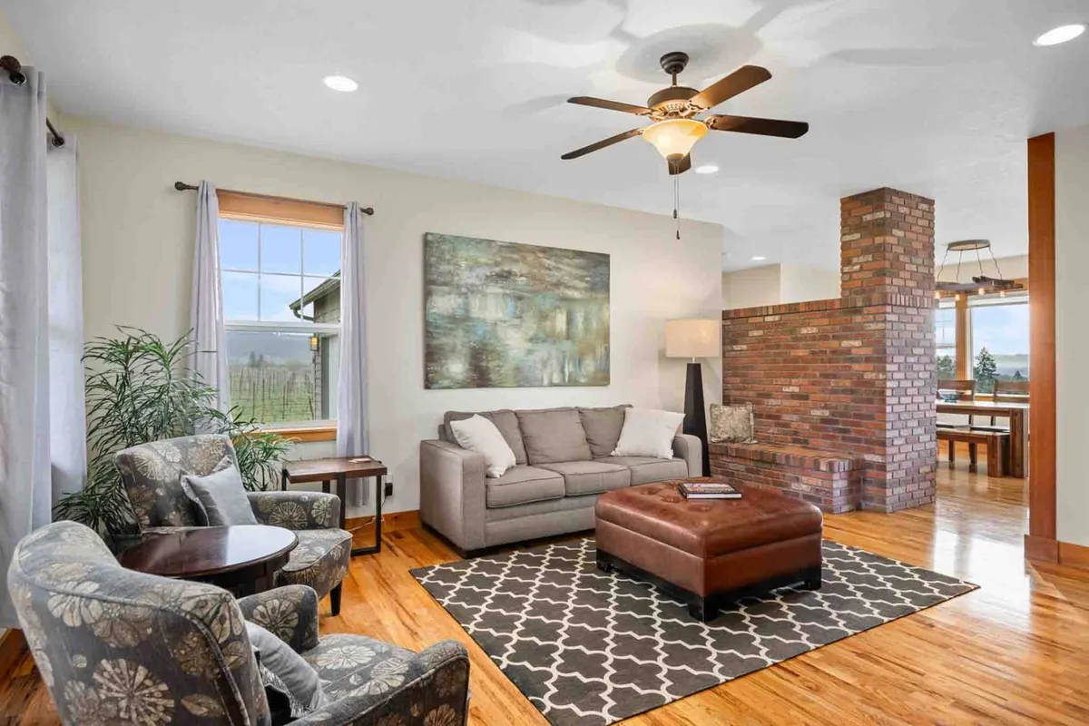A cozy and stylish living area with a comfortable sofa, coffee table, exposed brick wall, and artwork displayed on the wall. The space is inviting and designed for relaxation or socializing, reflecting the harmonious blend of comfort and aesthetic appeal.