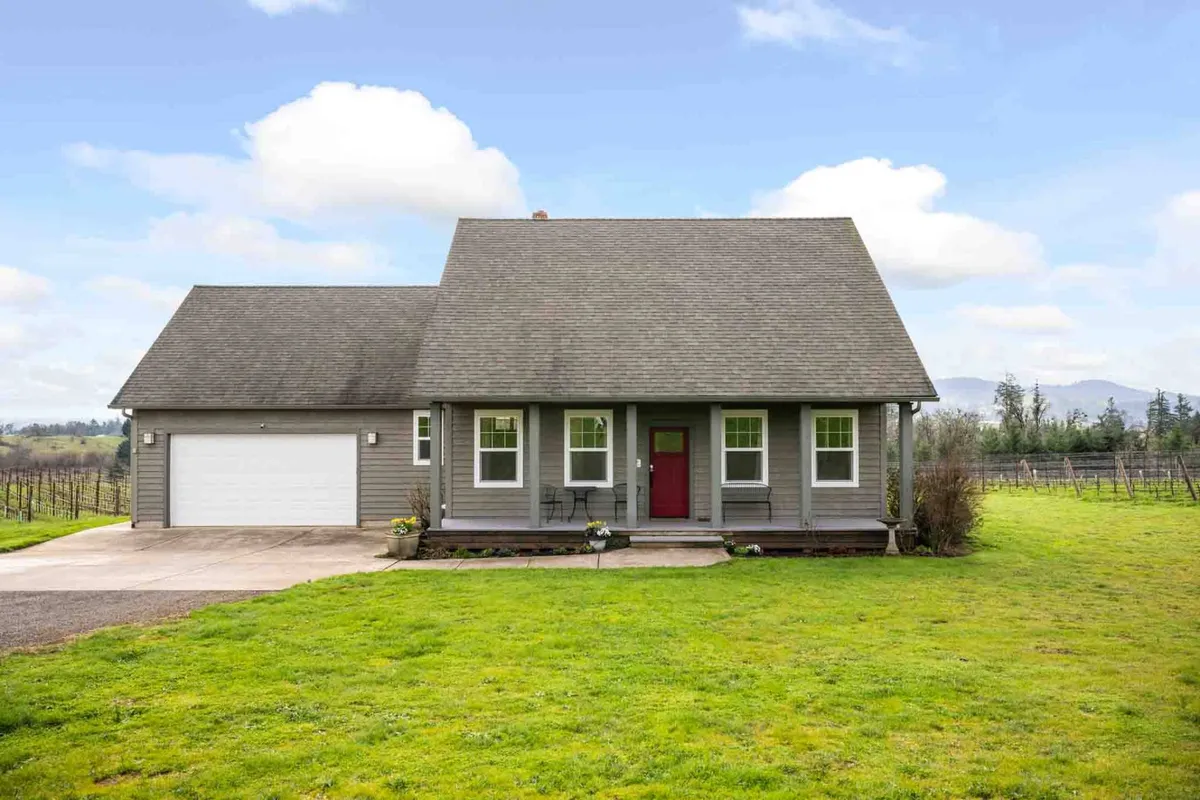 A well-maintained exterior shot of the home’s entrance, with landscaped yard and welcoming patio area. The inviting front door and open space hint at opportunities for outdoor gatherings, gardening, and watching sunsets over the fields.