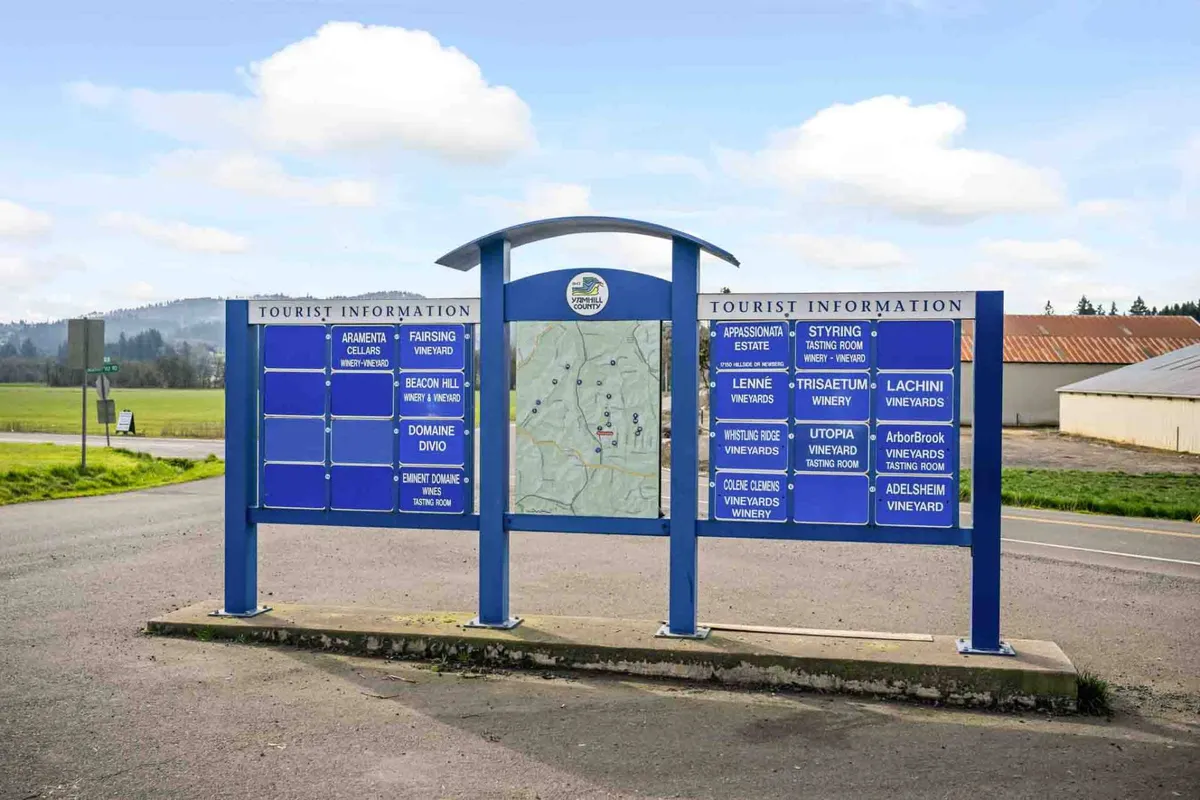 A friendly tourist information sign features a map of the area and a list of nearby vineyards, inviting guests to discover and connect with local wineries.